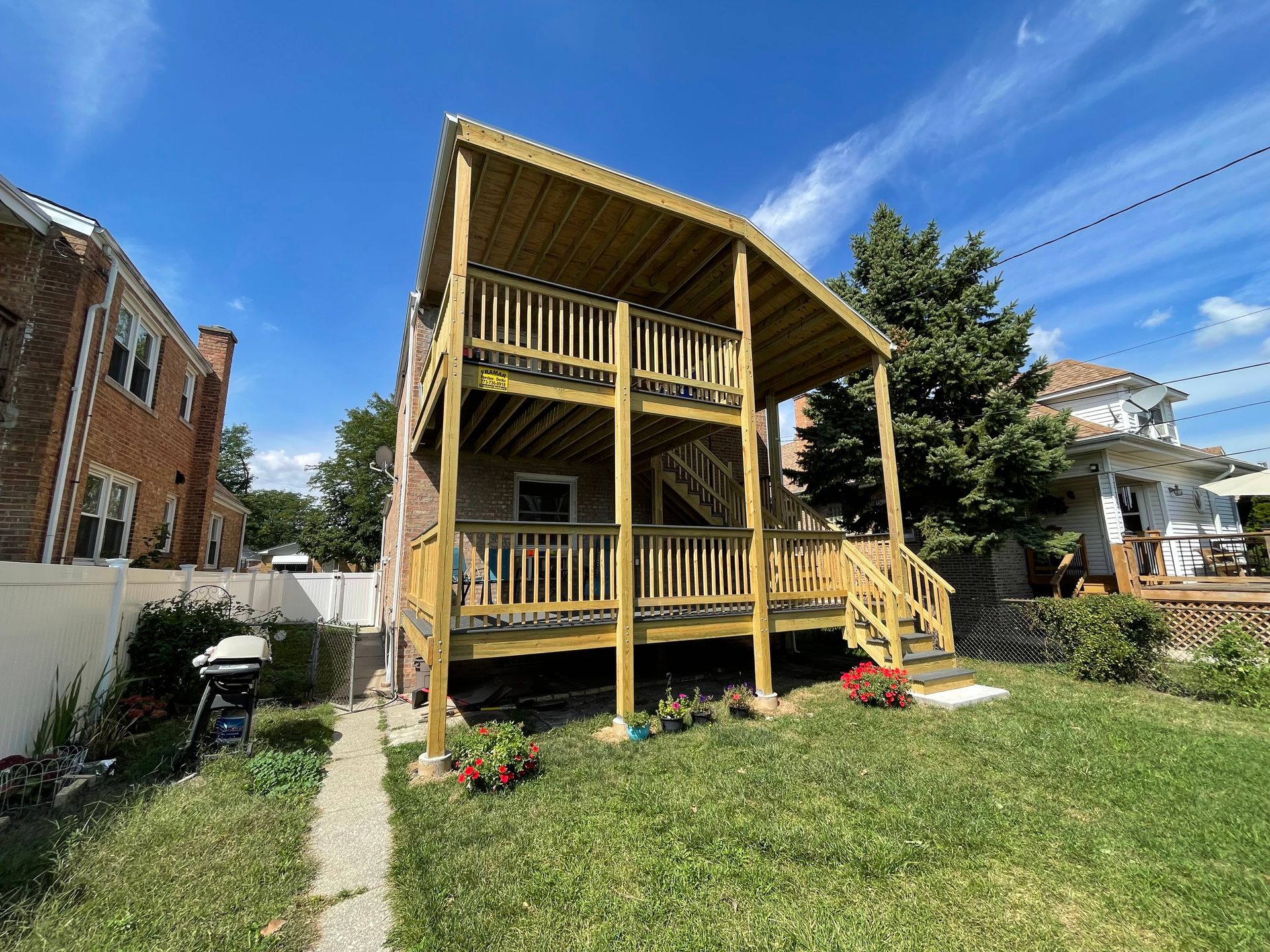 A house with a wooden deck and stairs in the backyard.