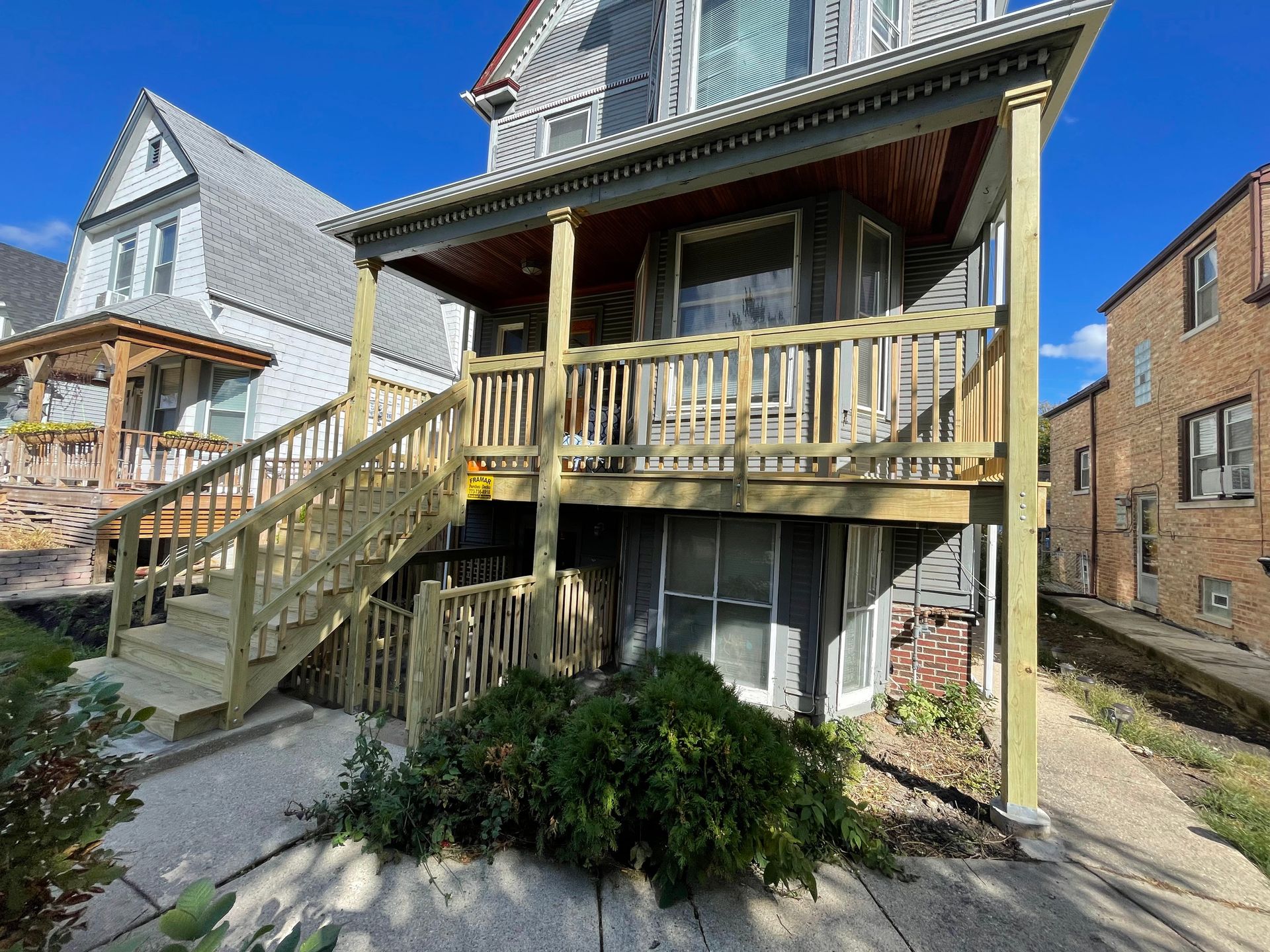 A house with a wooden deck and stairs on the side of it.