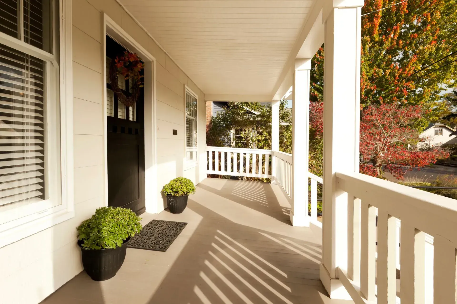 Stylish new porch in Chicago, IL, with a black door and white railing, showcasing Framar Porches Fra