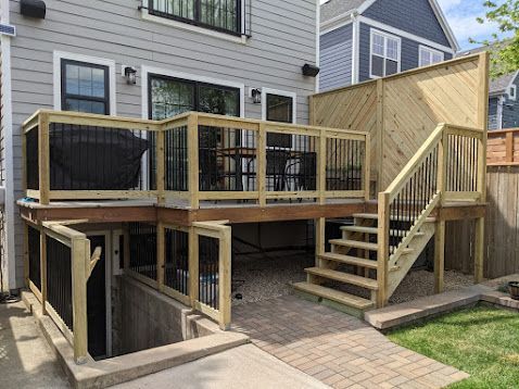 A man is using a drill on a wooden deck. A man is using a drill on a wooden deck.