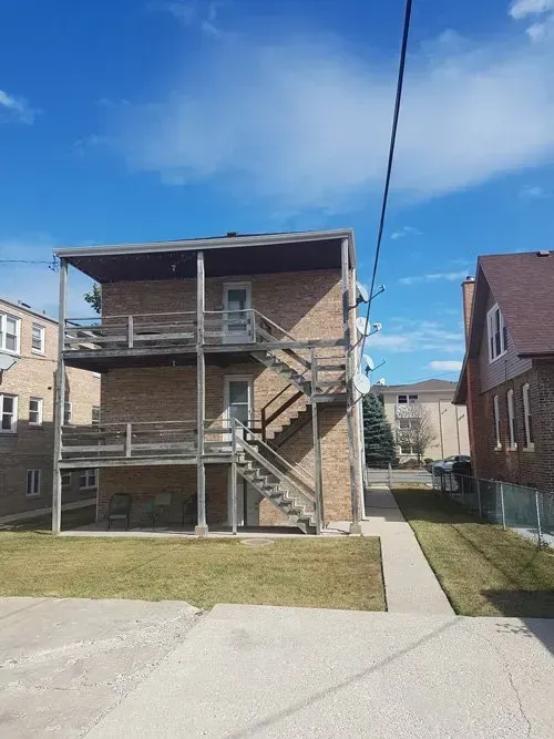 A brick building with stairs leading up to the second floor.