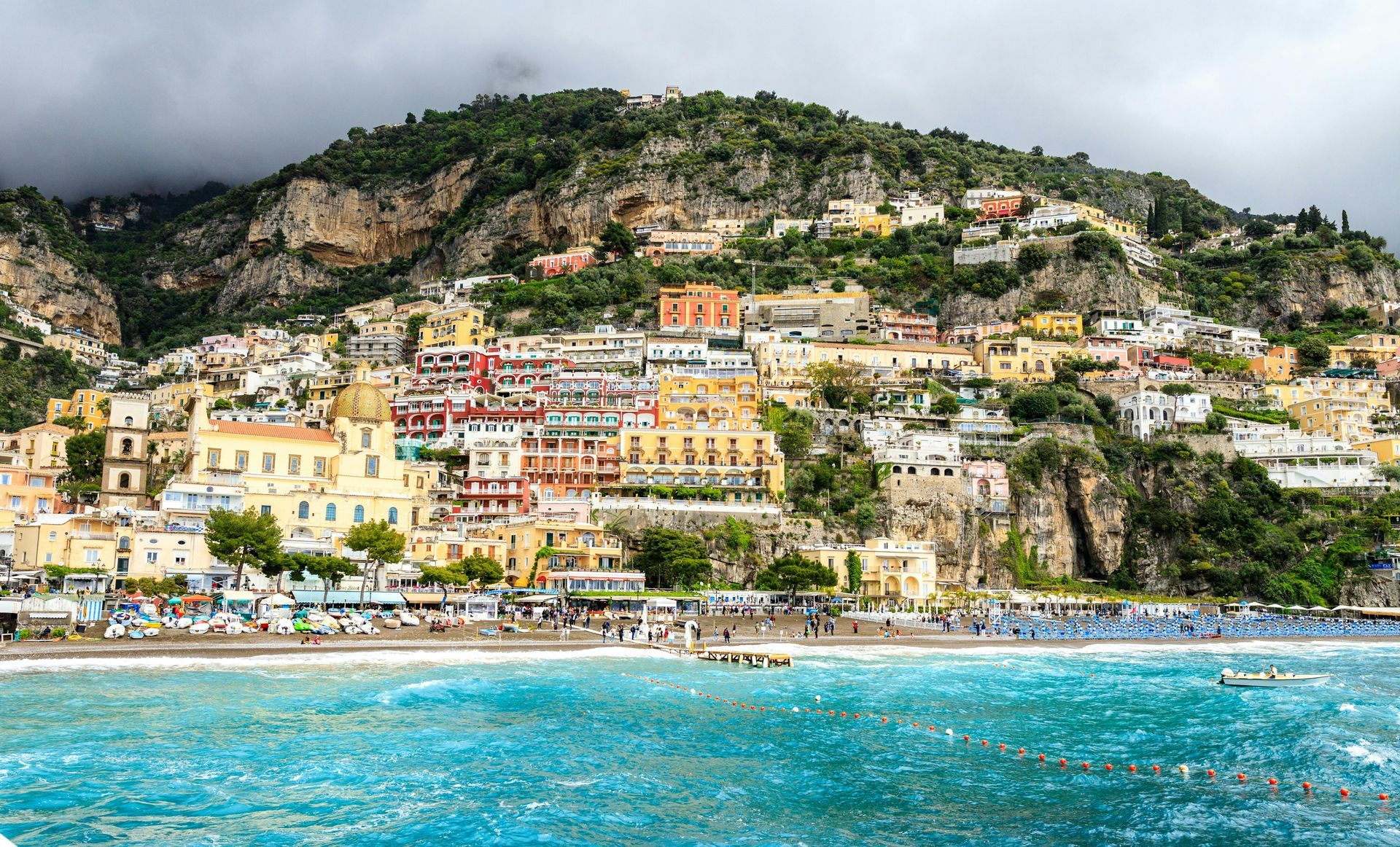 Colorful seaside village with pastel buildings on a hillside above turquoise water