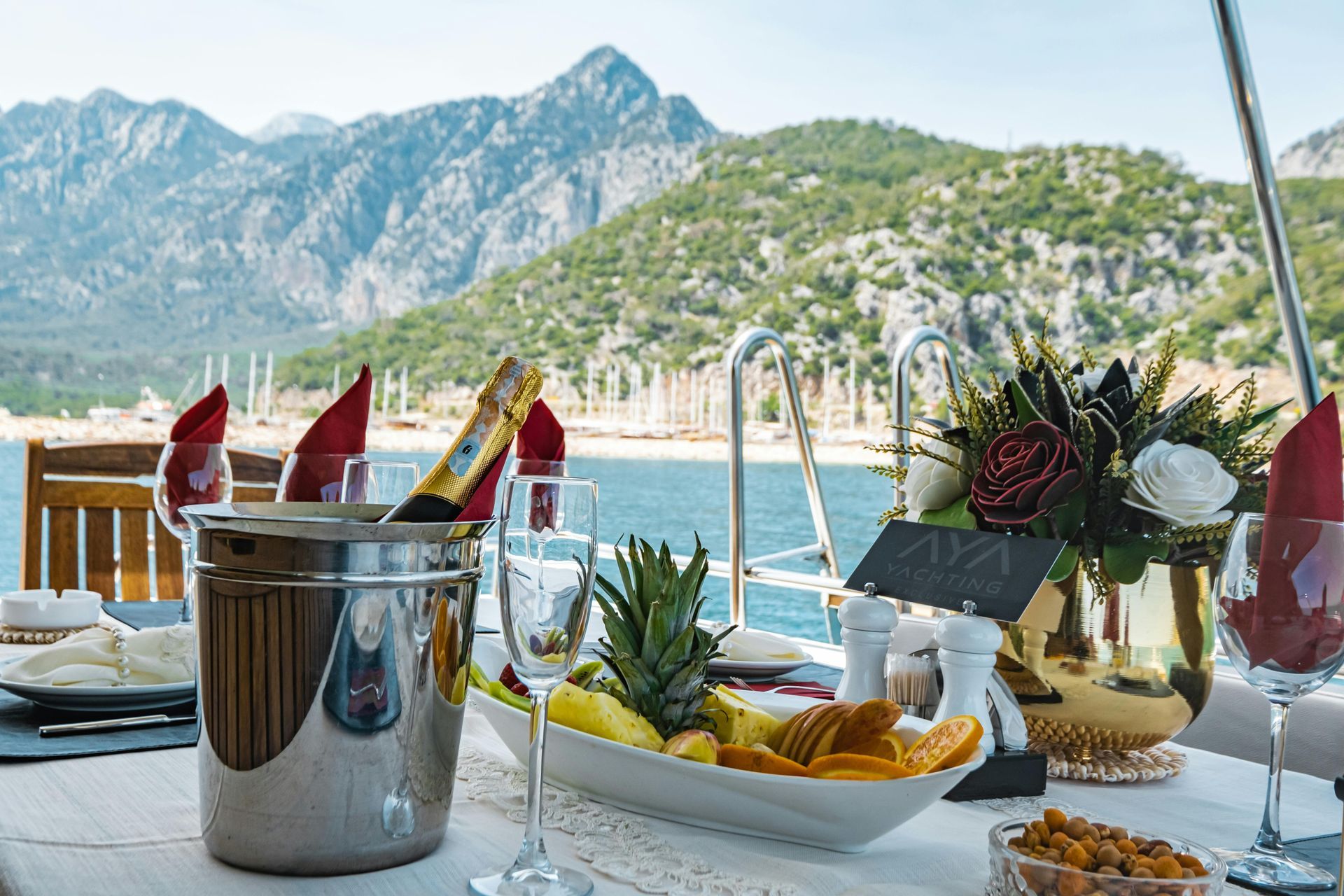 Seaside table with fruit and drinks, overlooking mountains and the sea