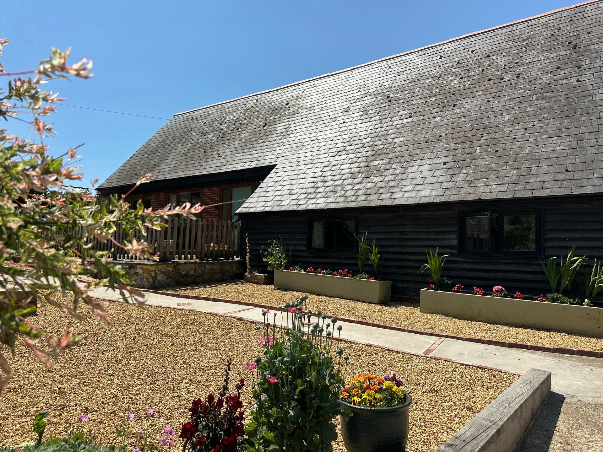 Outside front area of accommodation with flowers, pathway and graveled area.