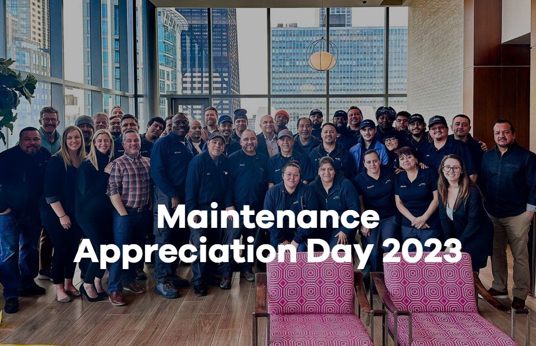 Maintenance Appreciation Day 2023 group photo in a bright room with large windows and city view