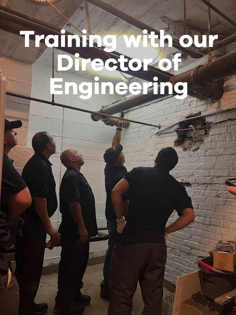 Group training session in a brick room, looking up at the ceiling with “Training with our Director of Engineering” text.