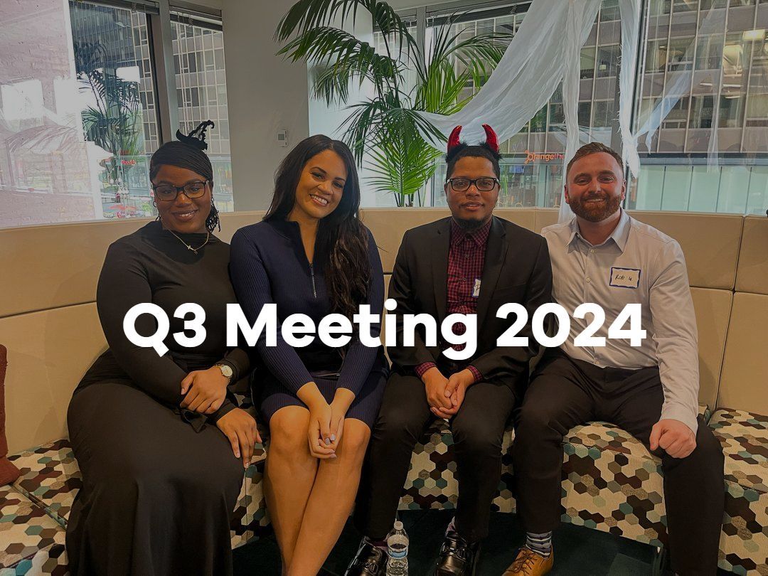 Four people seated on a couch at Q3 Meeting 2024, smiling in a bright office lounge