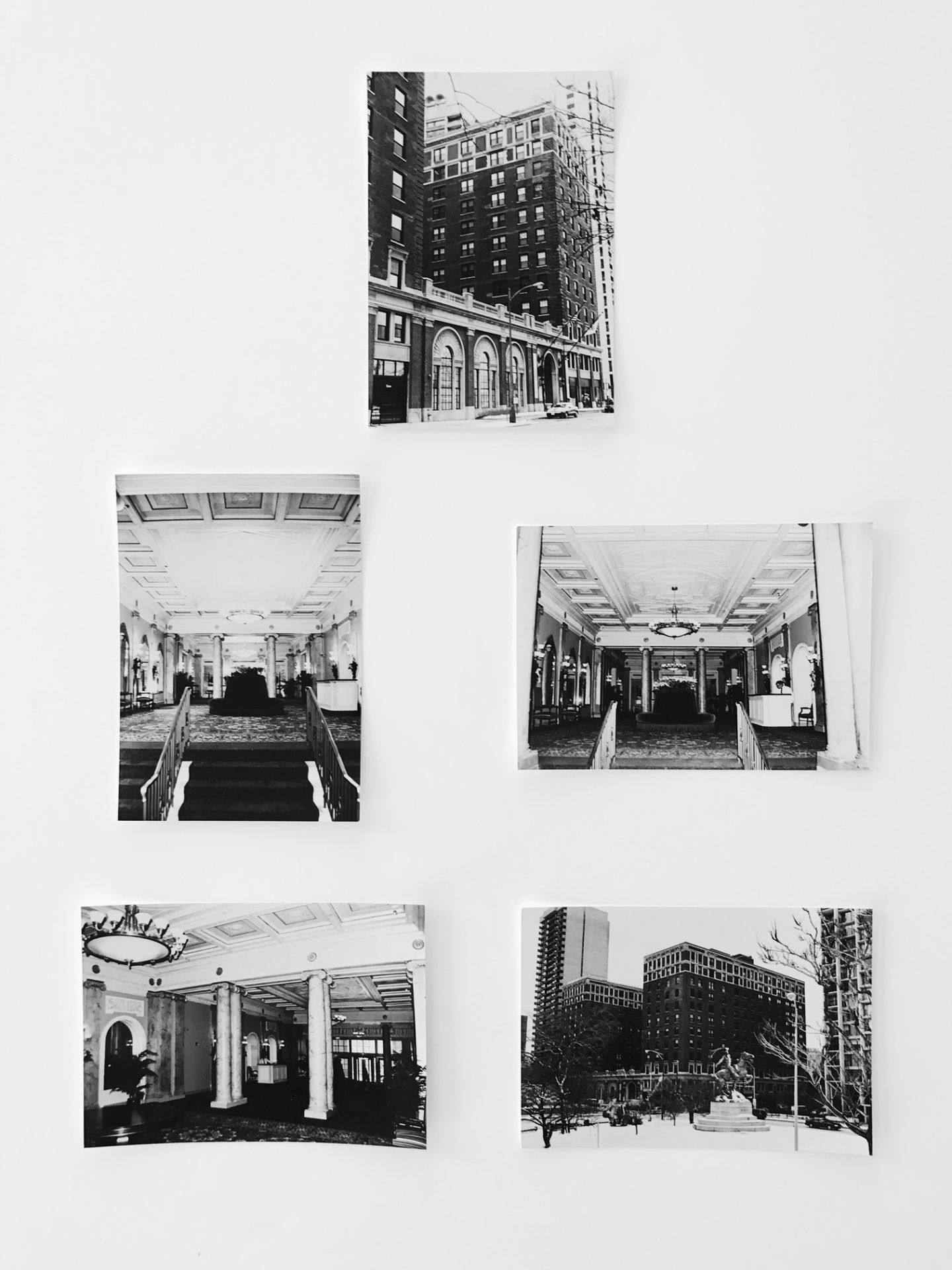 A collage of black and white photos of buildings on a white wall