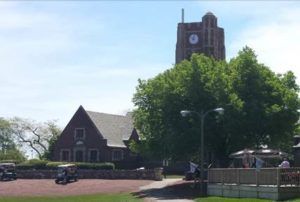 A large brick building with a clock tower in the background