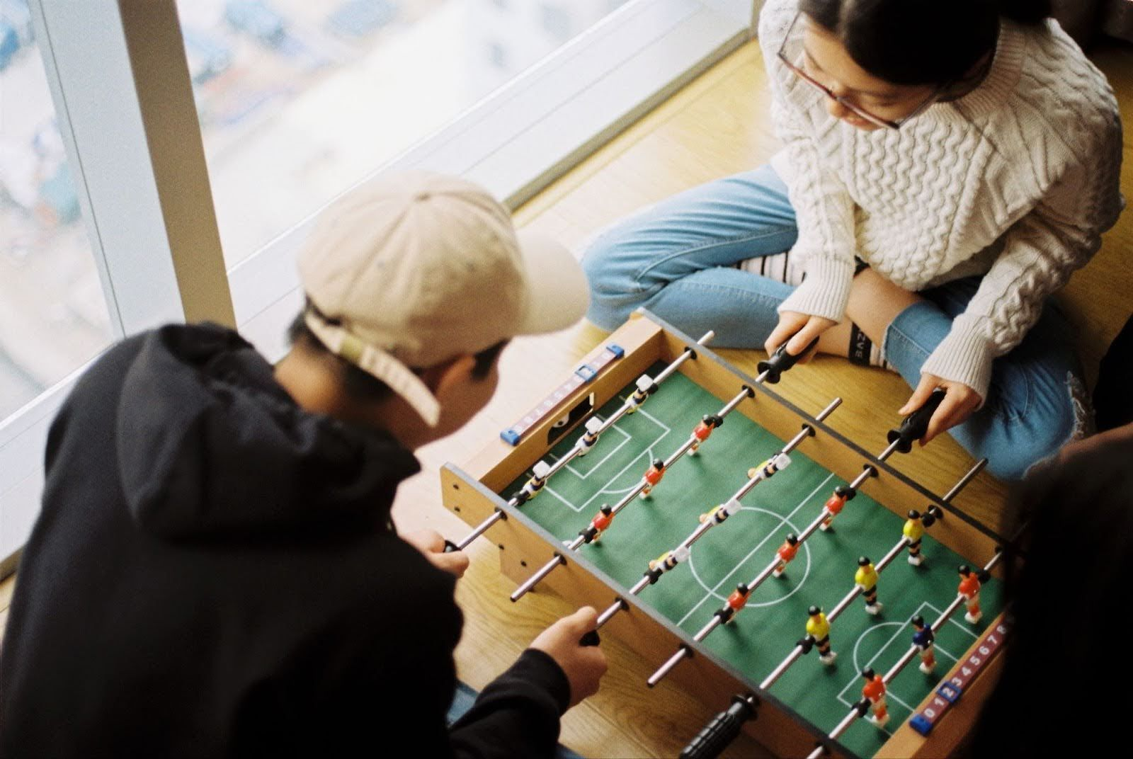 man and woman playing foosball game on floor