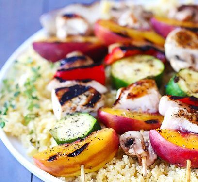 A plate of food with rice and vegetables on skewers