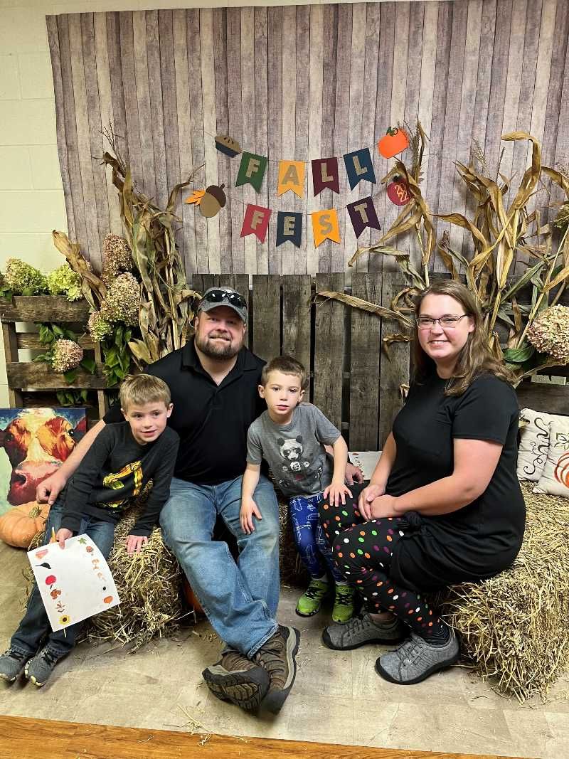 A family sitting in a fall backdrop