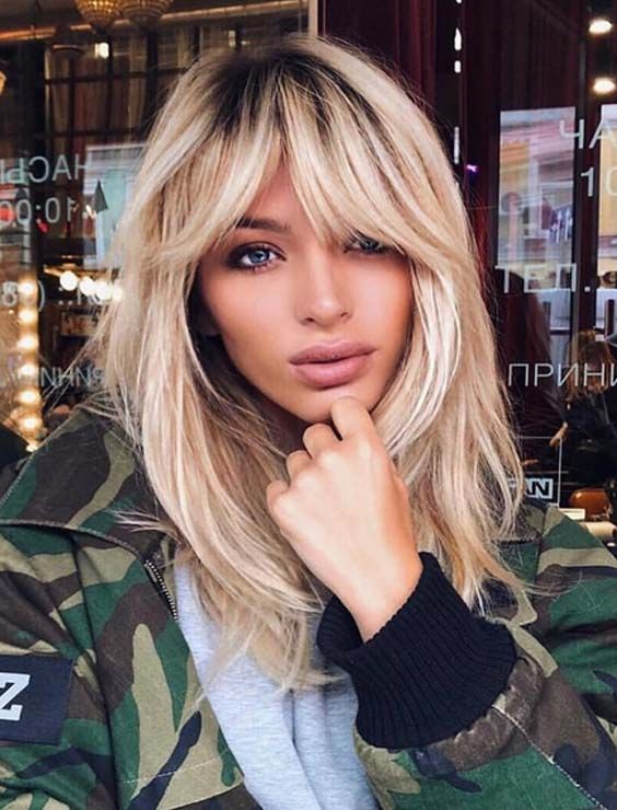 A woman with blonde hair is wearing a camouflage jacket