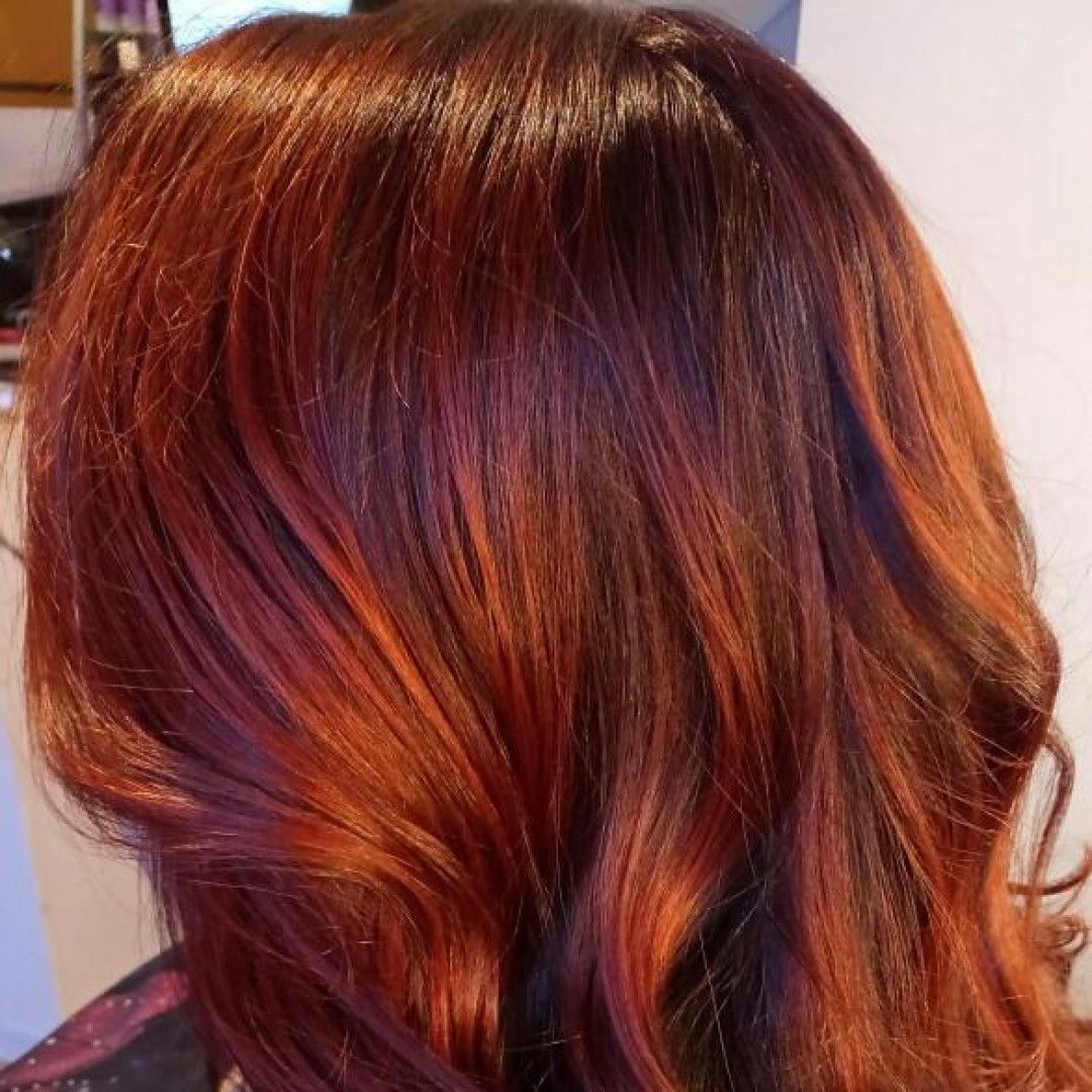 A close up of a woman 's hair with red highlights.