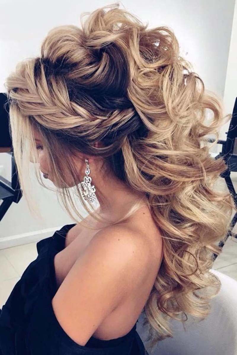 a woman wearing a black dress and earrings has her hair in a half up half down ponytail