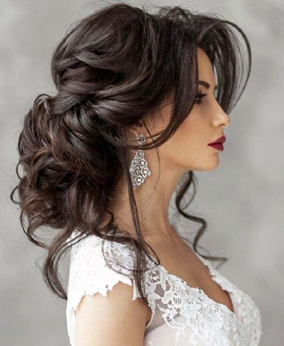 the woman is wearing a white lace dress and earrings .