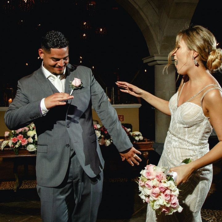 A man in a suit and a woman in a white dress are standing next to each other