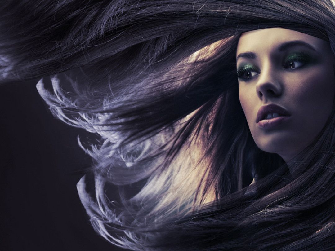 a woman with long hair is wearing green eye shadow