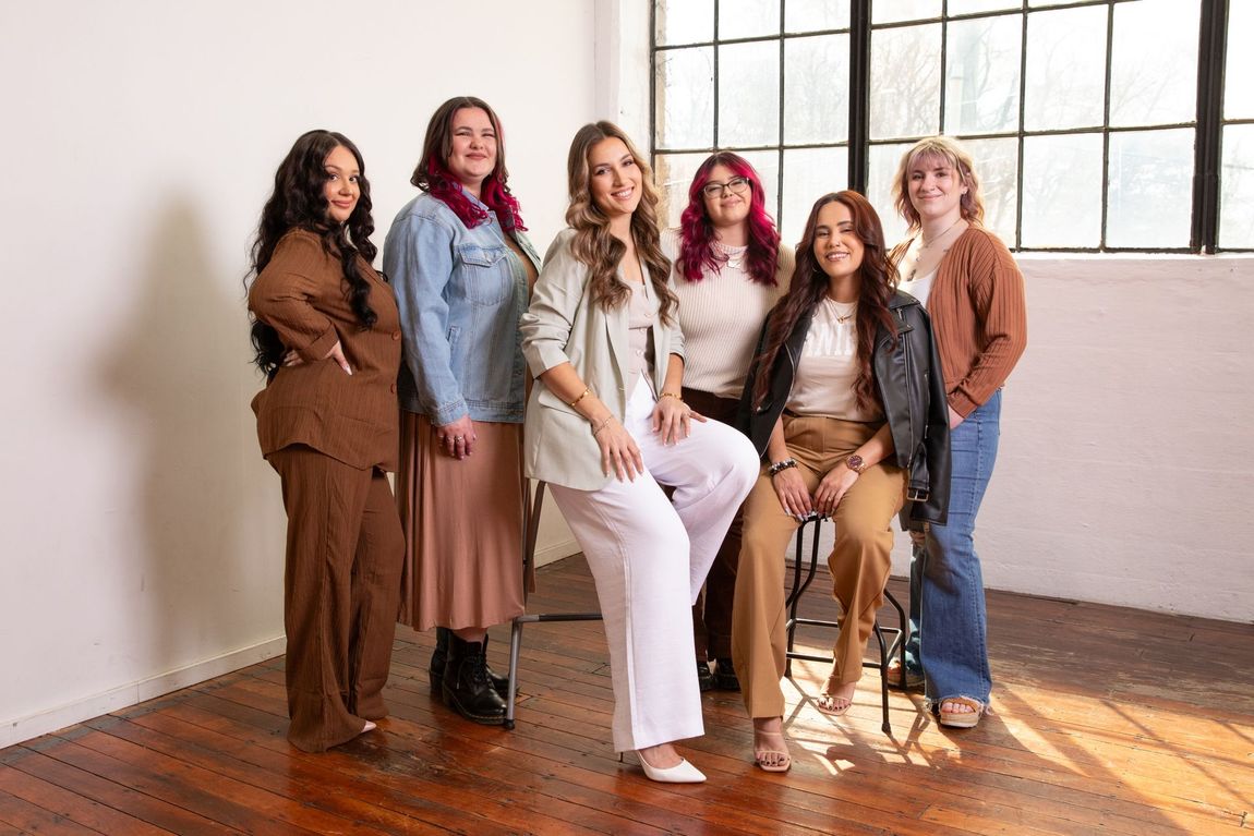 A group of women are posing for a picture in a room.