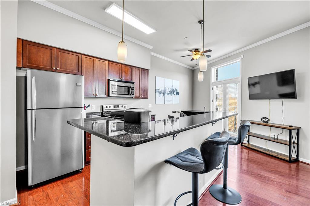 A kitchen with stainless steel appliances and granite counter tops.