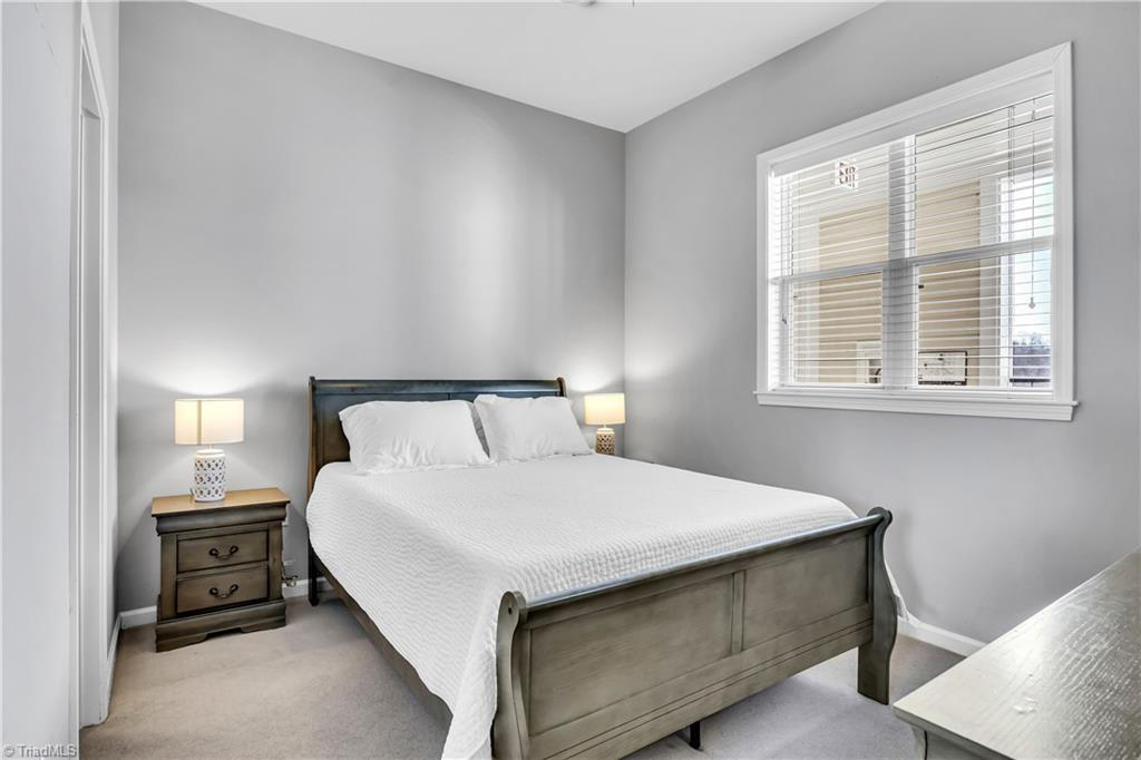 A bedroom with a bed , nightstand , and window.