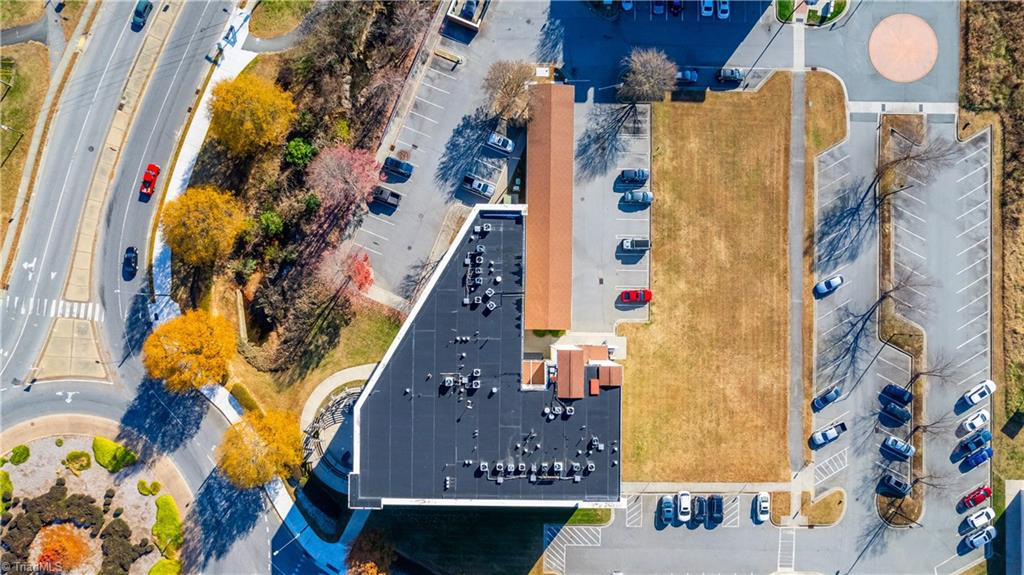 An aerial view of a building with a lot of cars parked in front of it.