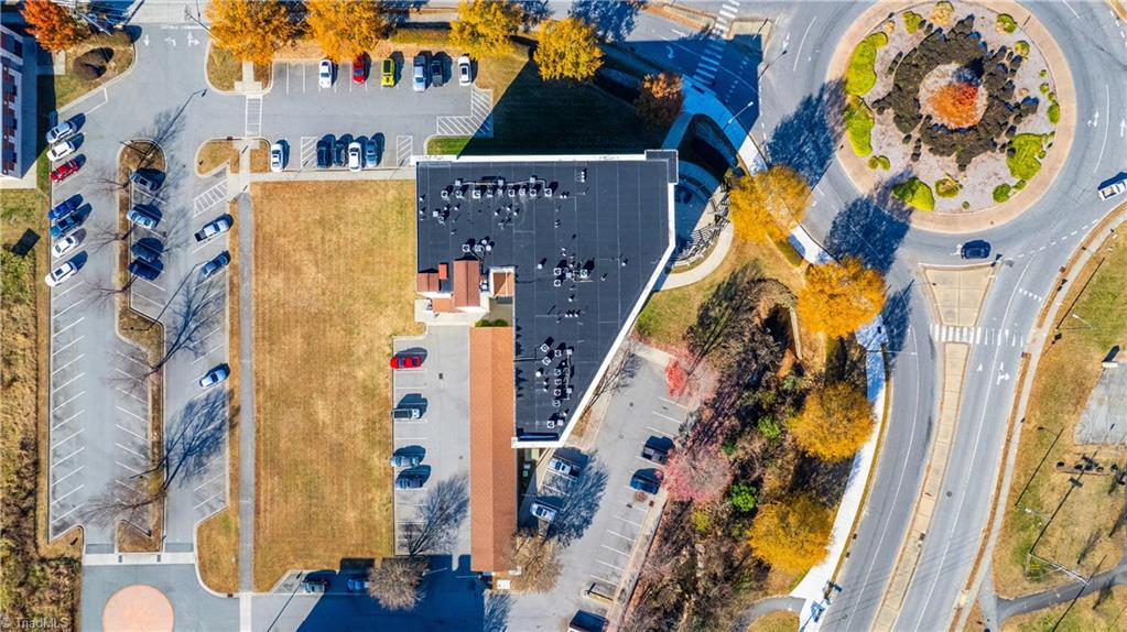 An aerial view of a building surrounded by trees and a roundabout.