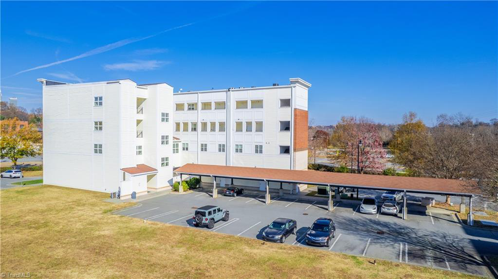 A large white building with a lot of cars parked in front of it.