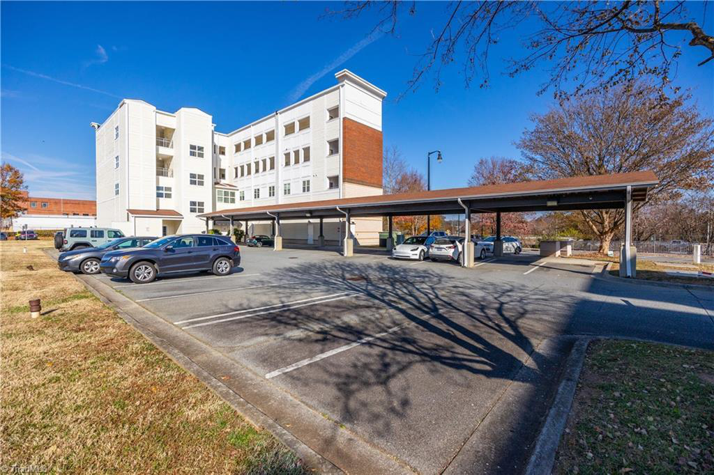 A parking lot with cars parked in front of a large building.