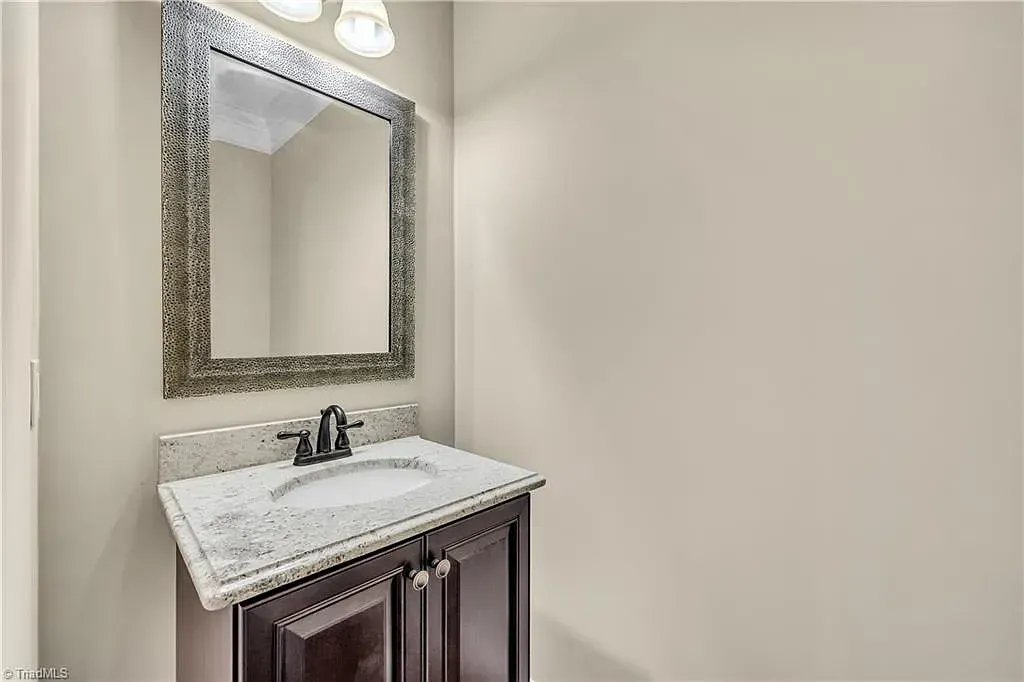 A bathroom with a sink , mirror and cabinets.