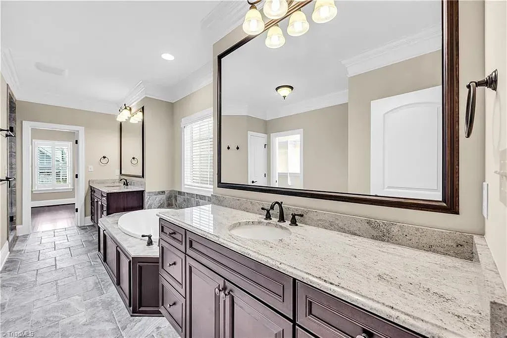 A bathroom with two sinks and a large mirror.