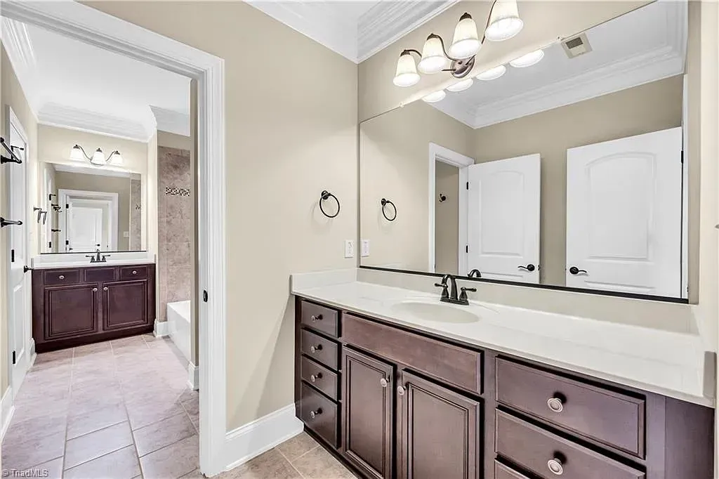 A bathroom with two sinks and a large mirror.