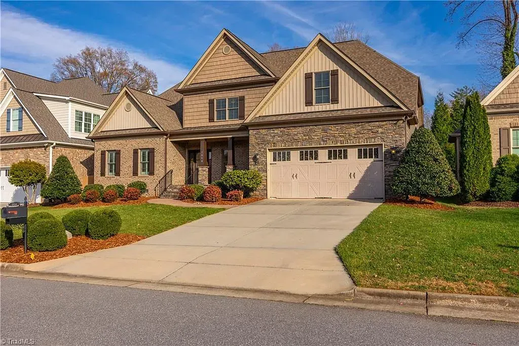 A large house with a large driveway in front of it.