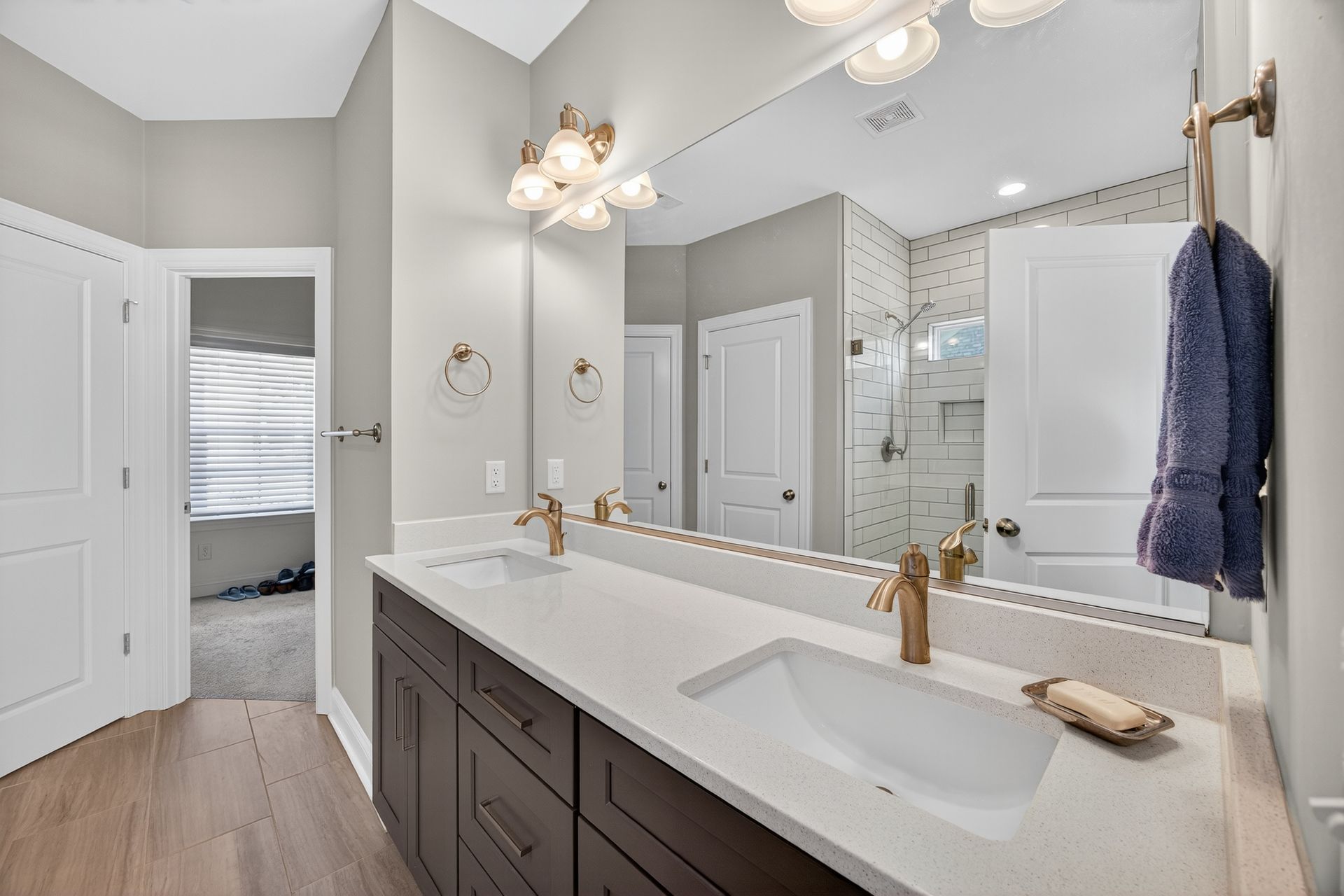 Bright modern bathroom with double vanity, large mirror, and walk-in shower.