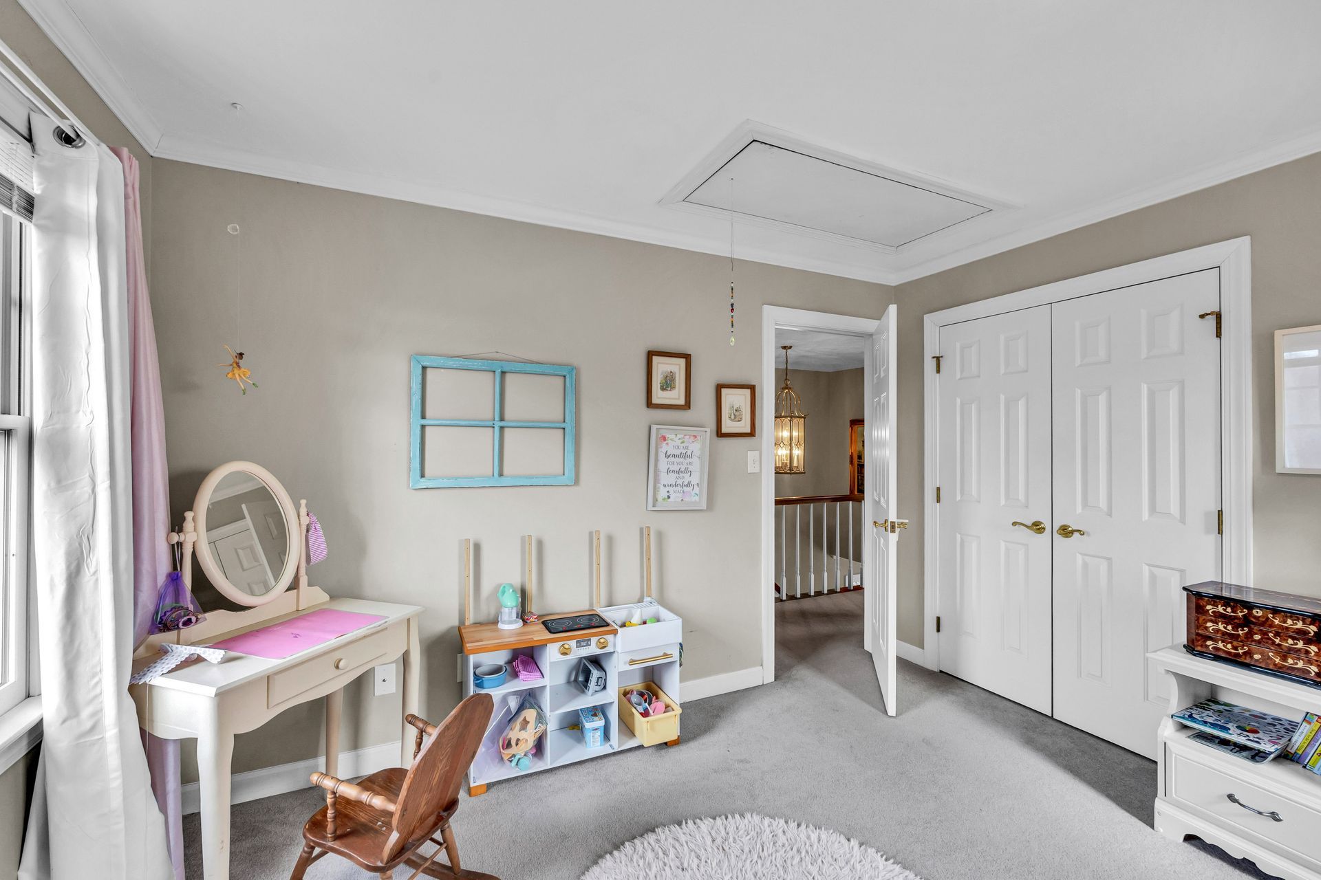 Bright child’s bedroom with white furniture, gray walls, and open closet door