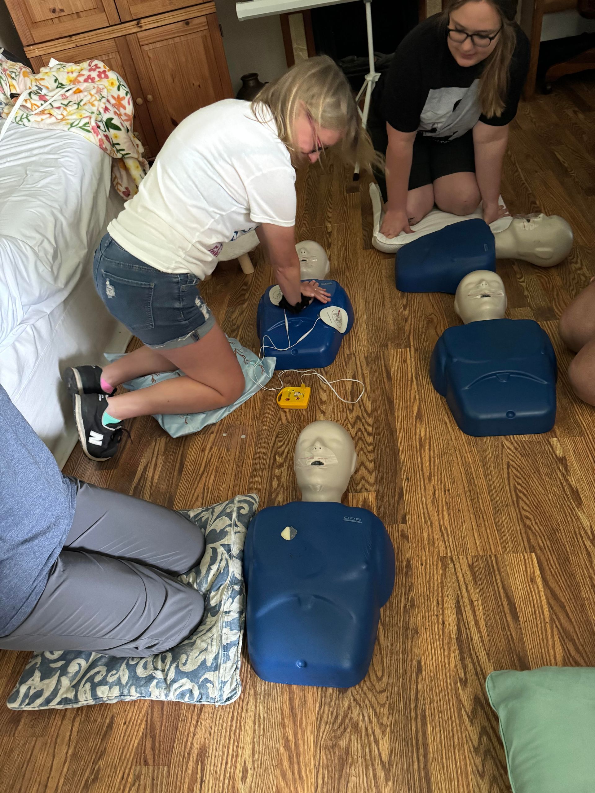 People practice CPR on mannequins during a training session.