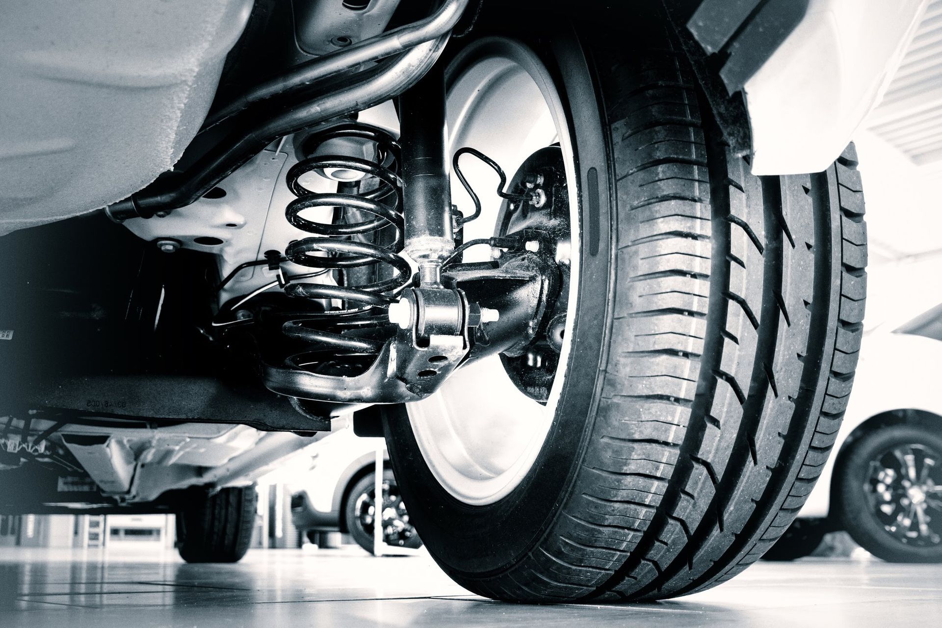 Ruota di scorta nera all'interno del bagagliaio di un'auto, circondata da schiuma bianca. Un'etichetta bianca è attaccata alla ruota.