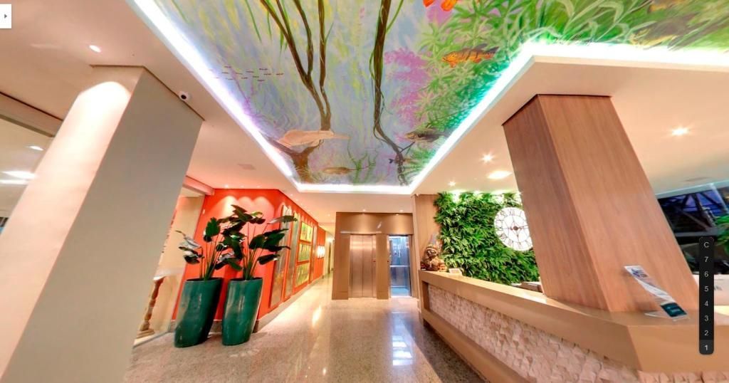 Hall de entrada do hotel com teto pintado com mural