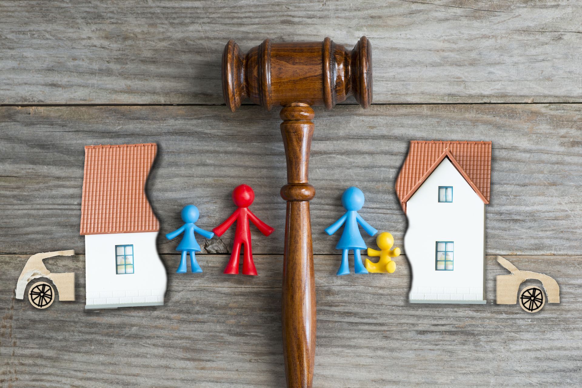 Divorce concept with a gavel dividing the family home and figures.