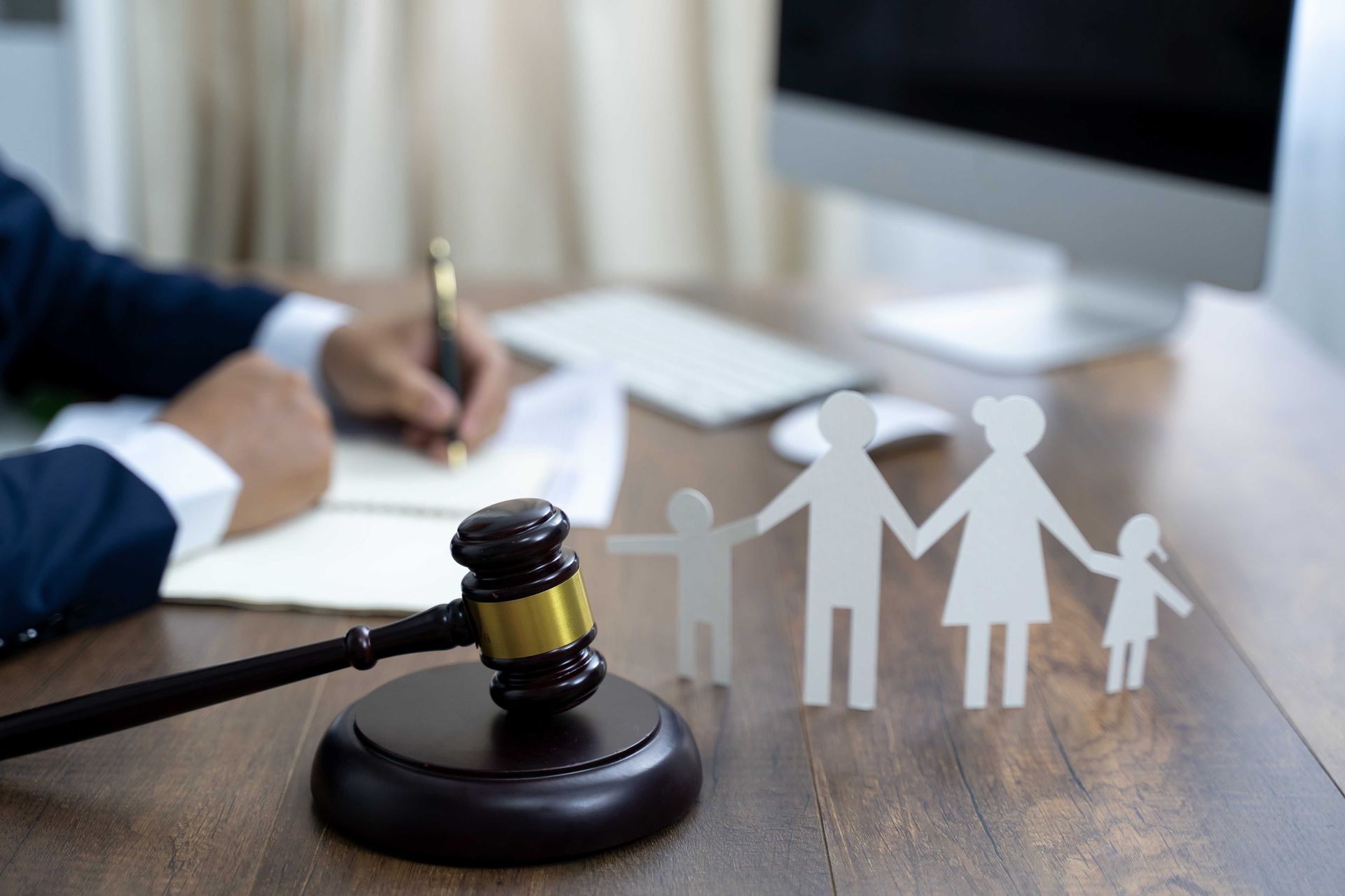 Family figure and gavel on wooden table.