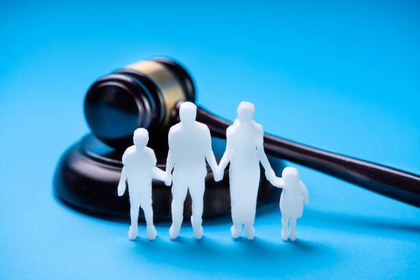 Family silhouettes before judge gavel symbolizing family law, custody and child support law.