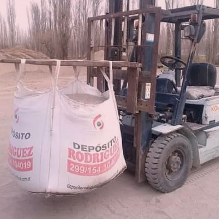 Una carretilla elevadora levanta una gran bolsa industrial blanca con la etiqueta “Depósito Rodríguez”