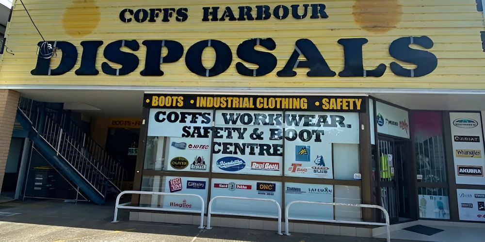 A Yellow Building With A Sign — Coffs Disposals, Workwear, Safety & Boot Centre in Coffs Harbour, NSW