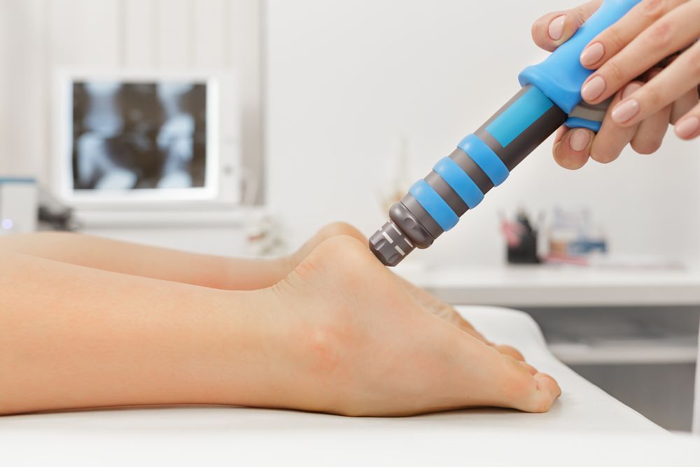 Person Receiving Shockwave Therapy on Ankle in Medical Setting — Biomedical Sports Podiatry in Forster, NSW