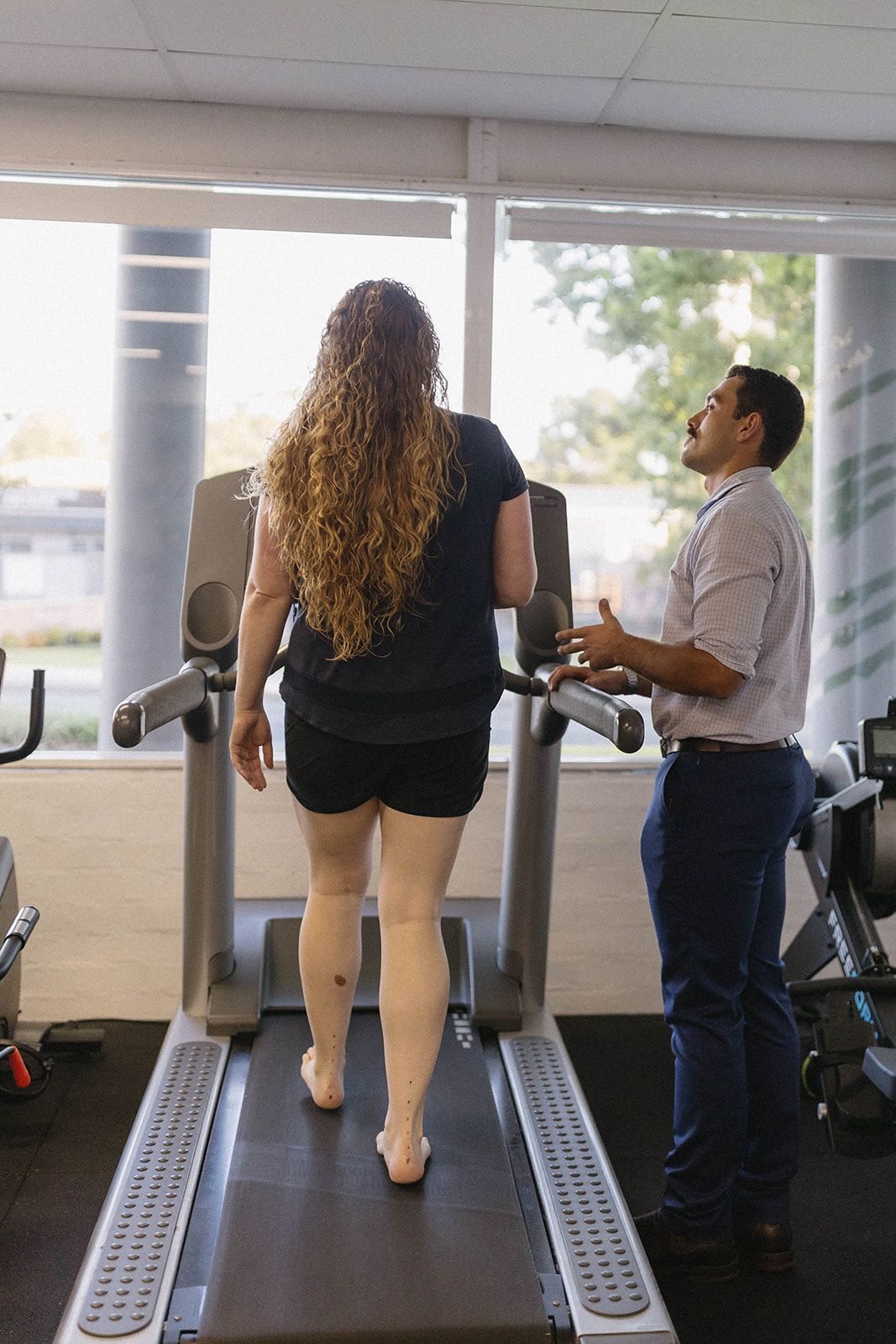 A Person Is Running on A Treadmill with Someone Beside Them — Biomedical Sports Podiatry in Forster, NSW
