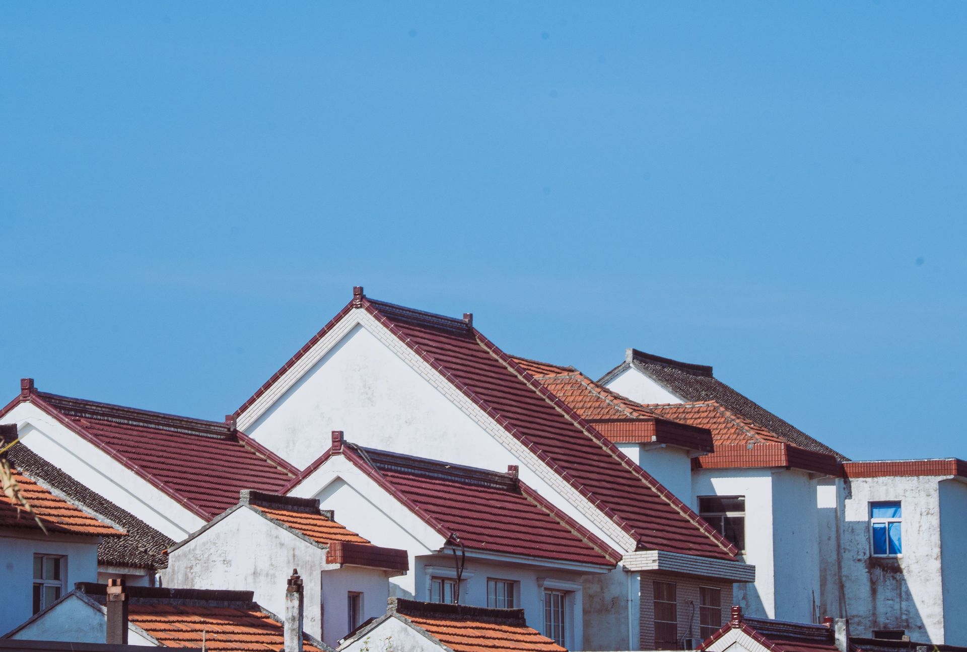 White houses with red tiled roofs beneath a clear blue sky