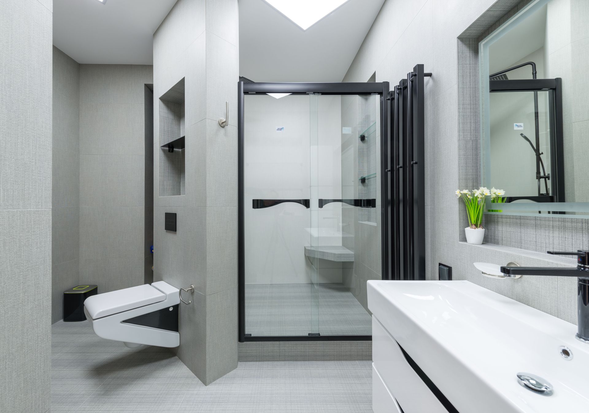 Modern gray bathroom with walk-in shower, toilet, and vanity sink