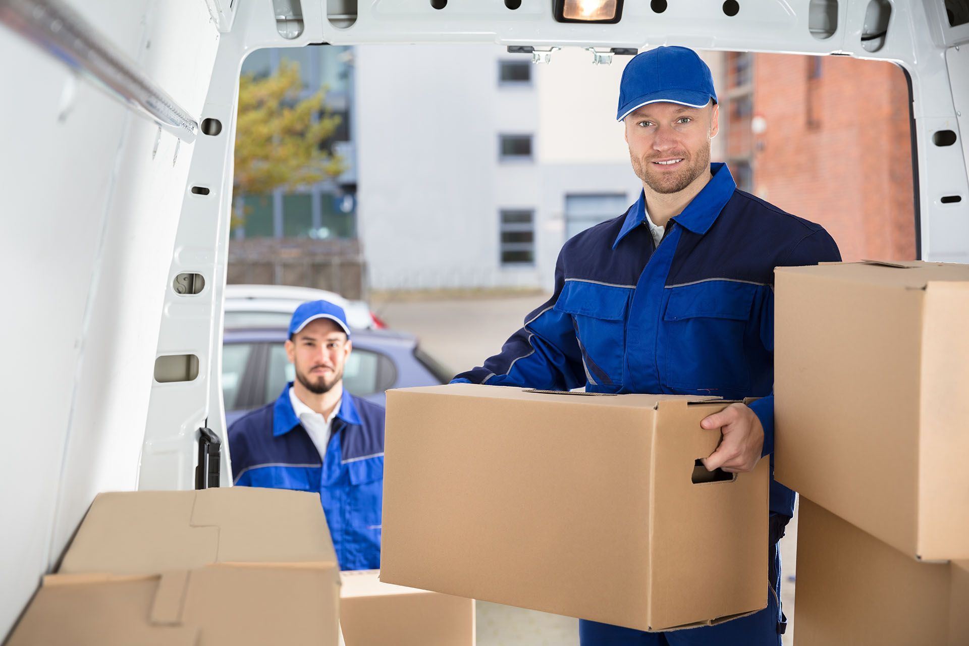 Cardboard boxes being unloaded from truck during professional furniture removals service. Cardboard boxes being unloaded from truck during professional furniture removals service.