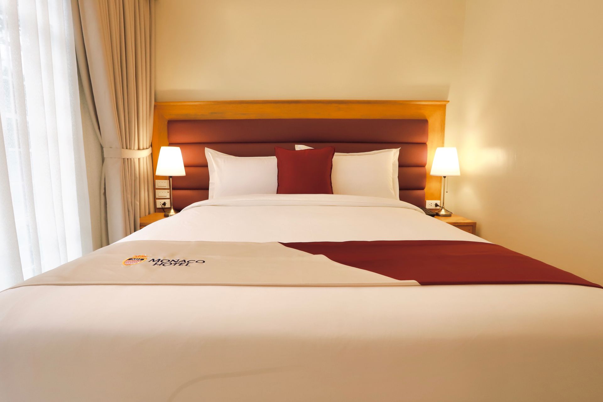 A hotel room with a king size bed and two lamps.