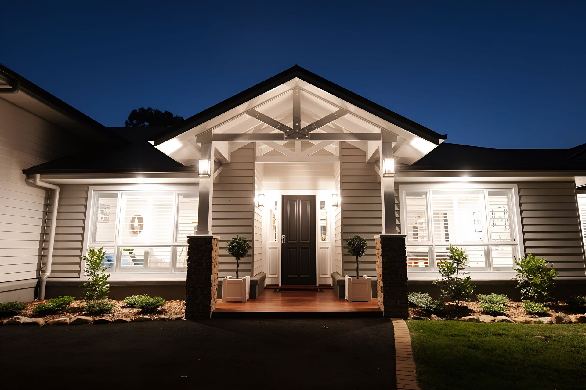 The Front of a House is Lit Up at Night — Michael Duncan Constructions Pty Ltd in Robina, QLD